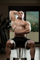 Fototapeta na wymiar Young Bodybuilder Exercise Triceps In The Gym