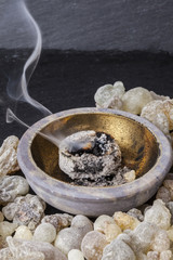 Frankincense burning on a hot coal. Frankincense is an aromatic resin, used for religious rites, incense and perfumes.