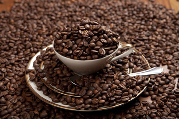 Kaffee-Bohnen in Tasse auf Holztisch 