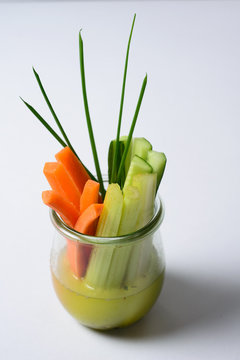 carrots , augures and onions in a glass