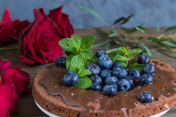 Chocolate cake with chocolate frosting and blueberries,roses