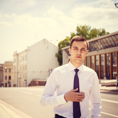 Stylish businessman in the sunglasses near building