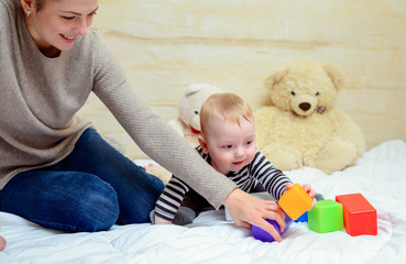 Pretty Mom with her Cute Baby Playing at Home