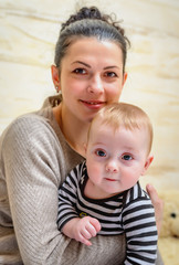Joyful loving young mother with her baby