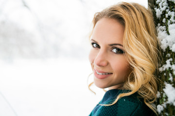 Fototapeta premium Smiling face of blond woman outside in winter nature