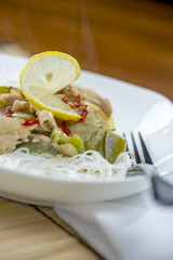Closeup view of a bowl of thai green curry and rice vermicelli noodle