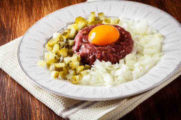 Steak tartare with egg yolk, onions and pickles