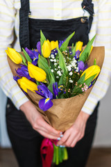 Florist hands showing bouquet of spring flowers. Selective focus.