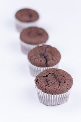 Brown chocolate muffins arranged over white background
