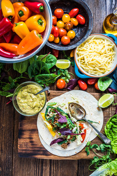Making traditional mexican fajitas or tortillas on wooden table,