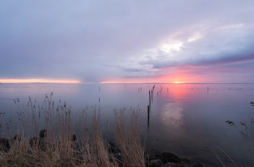 rode zonsopkomst boven een verstild Markermeer  kleurt een deel van de lucht