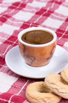 Cup of coffee with round tea cookies on the tablecloth