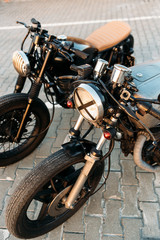 Two black and silver vintage custom motorcycles cafe racers