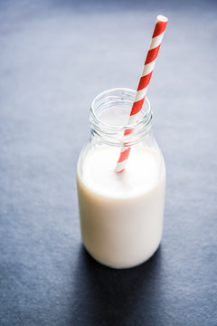 Traditional vintage milk bottle with striped straw