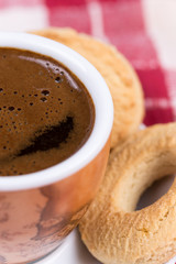 Black coffee with round tea cookies on the plate