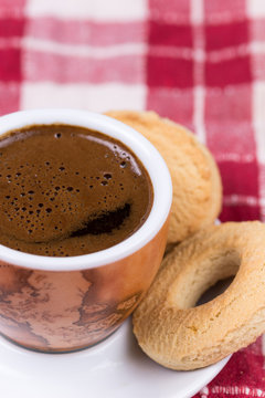 Black coffee with round tea cookies on the plate
