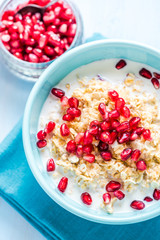 Homemade porridge with pomegranate seeds, overhead.