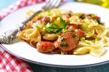Farfalle with sausage in tomato sauce.