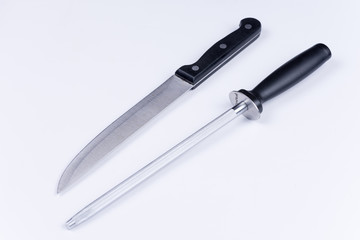 Kitchen knife and shrapening tool over white background