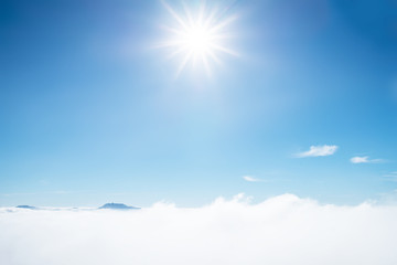 Sun rays shinning in the blue sky. Blue sky with layer of white hazy clouds.