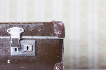 old suitcase on the background of vintage wallpaper