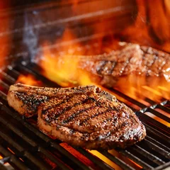 ribeye steaks on the grill over the open flame © Joshua Resnick