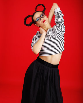 High fashion girl in the glasses with unusual hairstyle like Minnie Mouse in the studio