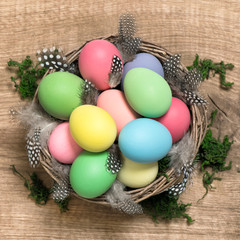 Easter eggs in basket on wooden background