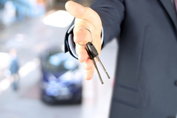 Car salesman handing over the keys for a new car 