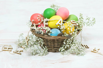 Easter eggs with flowers over bright wooden background