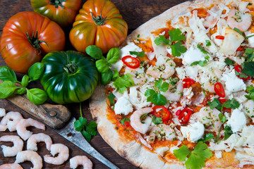 A hand stretched,wood fired pizza base topped with tomato and fresh basil,mozzarella cheese ,garlic king prawns,red chilli and coriander.