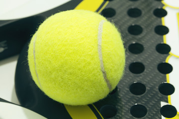 Paddle ball on racket. Yellow paddle ball laying on racket.