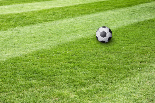 Conceptual soccer ball field background. Soccer ball waiting on sunny soccer field ground. 