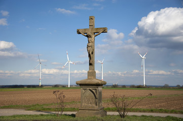 Fototapeta na wymiar Windräder auf den Feldern der Vorderpfalz mit Feldkreuz