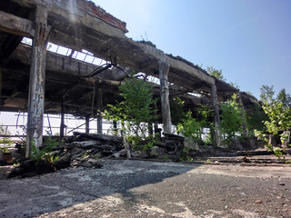 Abandoned industrial factory warehouse exterior crumbling - landscape color photo