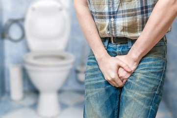 Incontinence concept. Man wants to pee and is holding his bladder.