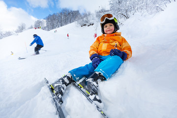 Fototapeta na wymiar Child rest sitting in snow on side of ski track