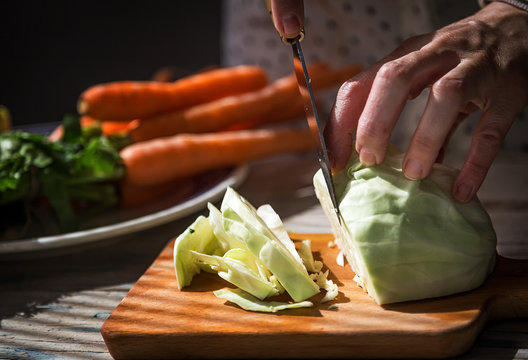 Cook on a wood cutting vegetables