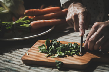 Cook on a wood cutting vegetables