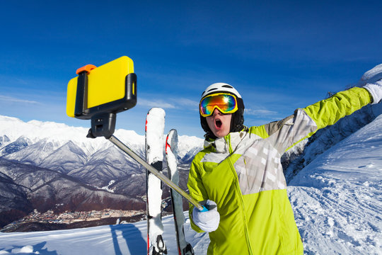 Happy screaming skier take photo with camera