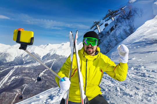Happy skier man taking selfie on mountain