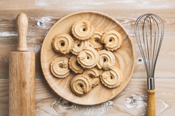 Danish butter Cookies in wood dish on wood table, top view