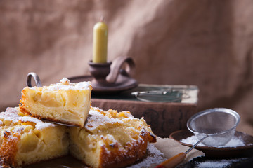 Apple cake on a vintage suitcase in powdered sugar.selective focus.