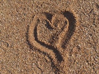 Fototapeta na wymiar A heart drawn in small seashells at the beach