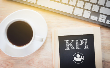 Concept KPI message on wood boards. A keyboard and a glass coffee table.Vintage tone.