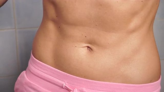 Woman showing some strong abs and flat belly close up 4K