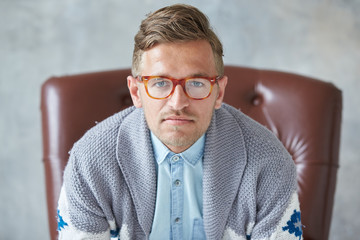 Portrait of a stylish intelligent man with glasses stares into the camera, good view, small...