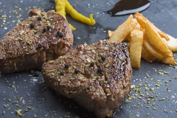 Grilled T-bone steak seasoned with spices and fresh herbs served