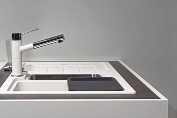 White kitchen sink with modern faucet