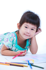 Child lie on the floor and drawing on paper.  On white